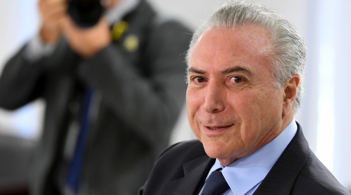 Brazilian President Michel Temer gestures during a ministerial meeting at Planalto Palace in Brasilia, Brazil, on August 28, 2017.
Temer is expected to travel on Tuesday to China for an eight-day visit which will include his participation in the September 3-5 summit of BRICS countries: Brazil, Russia, India, China and South Africa. / AFP PHOTO / EVARISTO SA
Caption