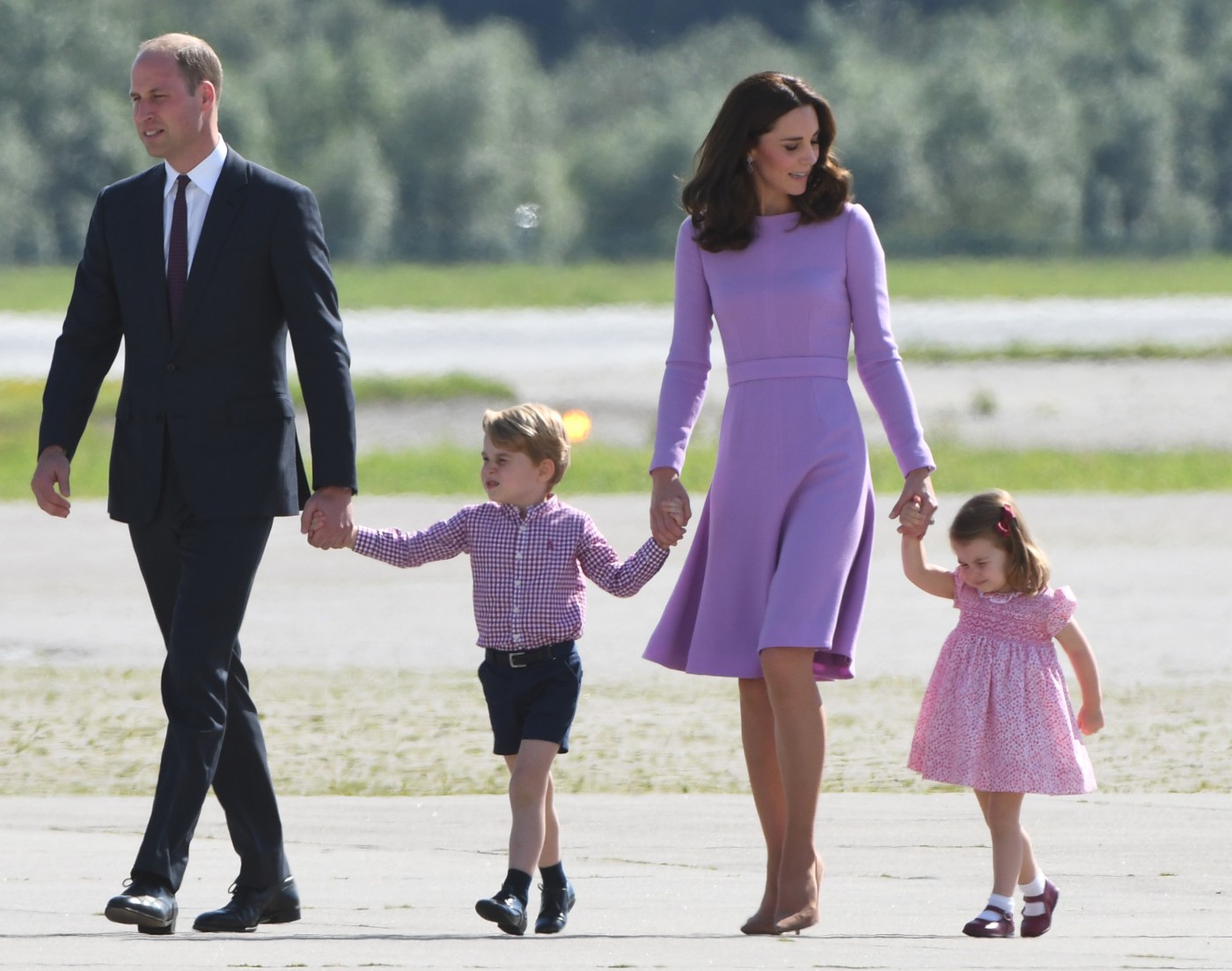 (FILES) This file photo taken on July 21, 2017 shows Britain's Prince William, Duke of Cambridge and his wife Kate, the Duchess of Cambridge, and their children Prince George and Princess Charlotte on the tarmac of the Airbus compound in Hamburg, northern Germany.
Prince William and his wife Kate are expecting their third child, Kensington Palace announced on September 4, 2017, adding that she would not be attending a planned engagement due to a severe form of morning sickness. / AFP PHOTO / Patrik STOLLARZ - AFP/Patrik STOLLARZ/21.07.17