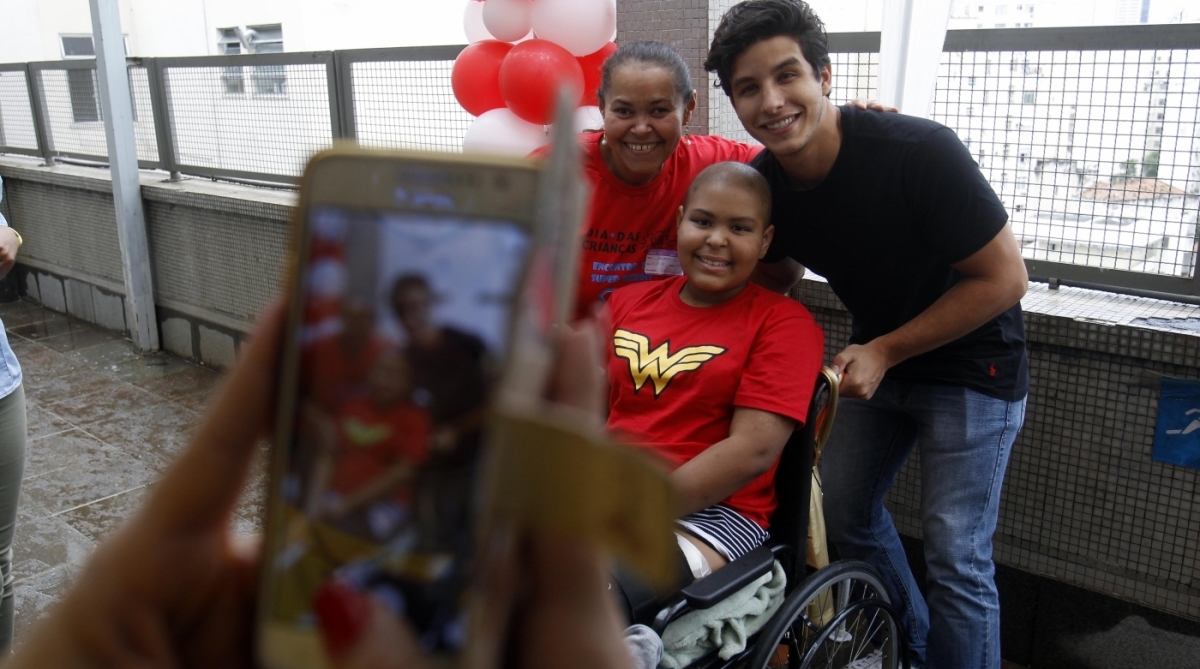 Ricky Tavares durante fotos com crian&ccedil;as