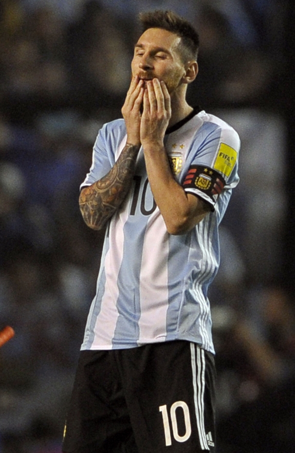 Argentina's forward Lionel Messi (R) gestures next his teammate forward Dario Benedetto during their 2018 FIFA World Cup qualifier football match against Peru, at La Bombonera stadium, in Buenos Aires, on October 5, 2017. / AFP PHOTO / ALEJANDRO PAGNI
      Caption