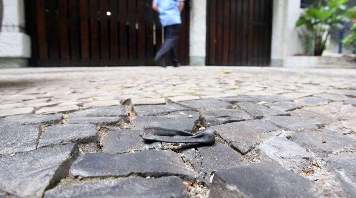 2017-10-13 - Bomba em Laranjeiras  Na foto: Porteiro observa buraco em port&atilde;o de garagem  em pr&eacute;dios da Rua Moura Brasil, 60, provocados pelos estilha&ccedil;os de bomba que foi jogada Foto:  Luiz Ackermann / O Dia