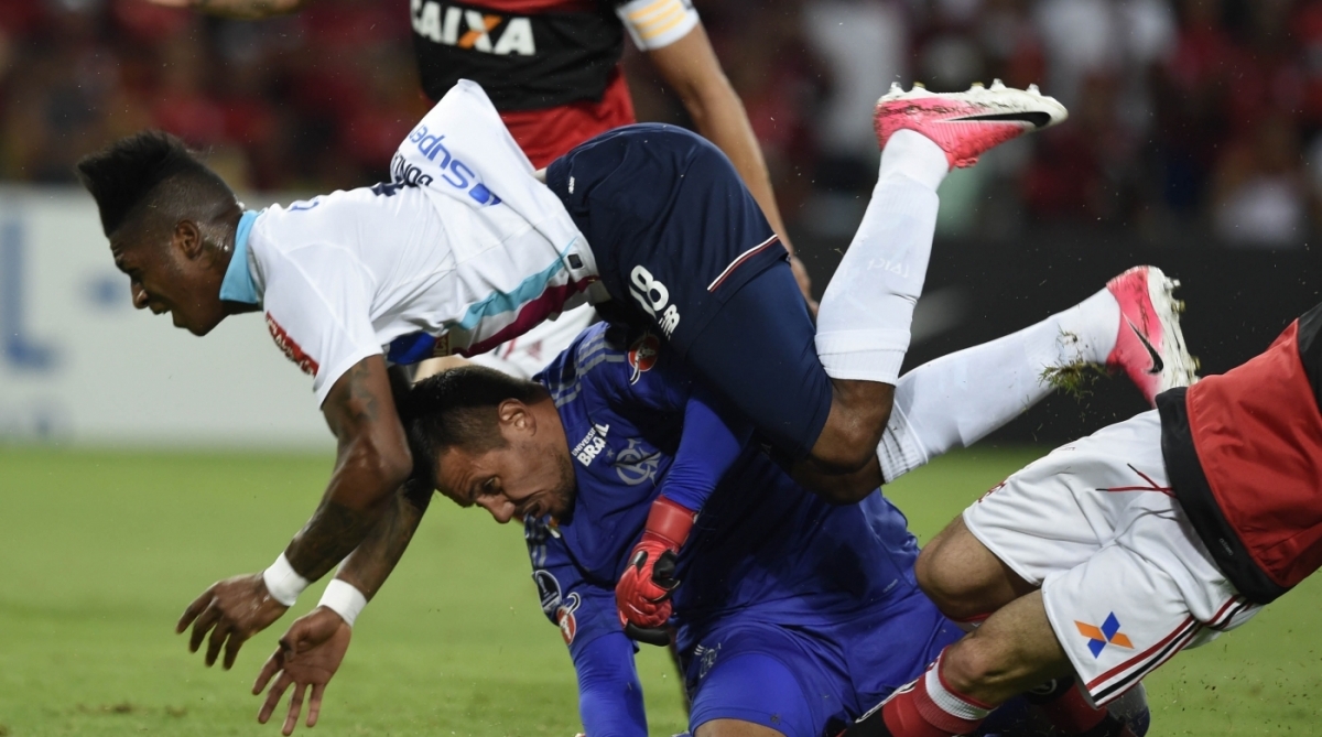 Yony Gonzalez (top) of Colombia's Junior de Barranquilla falls on top of goalkeeper Diego Alves of Brazil's Flamengo (bottom) during their Copa Sudamericana 1st leg Semi Final soccer match at Maracana football stadium in Rio de Janeiro, Brazil, on November 23, 2017.  / AFP PHOTO / LEO CORREA
      Caption
