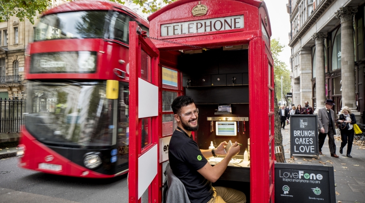 A pedestrian walks past a coffee shop run by Umar Khalid (unseen) in a red telephone box in Hampstead Heath, north London on October 20, 2017.
Facing extinction due to ubiquitous mobile phones, Britain's classic red telephone boxes are being saved from death row by ingenious conversions into all sorts of new uses. / AFP PHOTO / Tolga Akmen / TO GO WITH AFP STORY 'Britain-heritage-business' by Martine PAUWELS