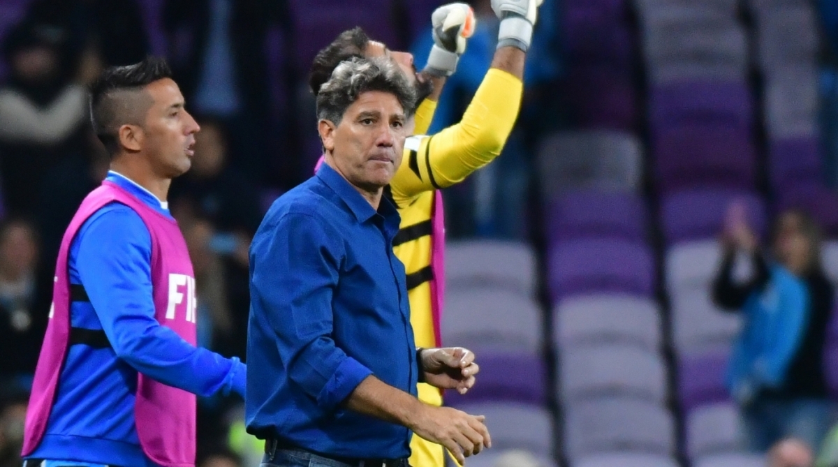 Gremio FBPA's coach Renato Gaucho (front) of Brazil walks with members of his team celebrating after winning the first semi-final football match of the FIFA Club World Cup UAE 2017 between Gremio FBPA and CF Pachuca at the Hazza Bin Zayed Stadium in Al Ain on December 12, 2017.  / AFP PHOTO / GIUSEPPE CACACE
      Caption