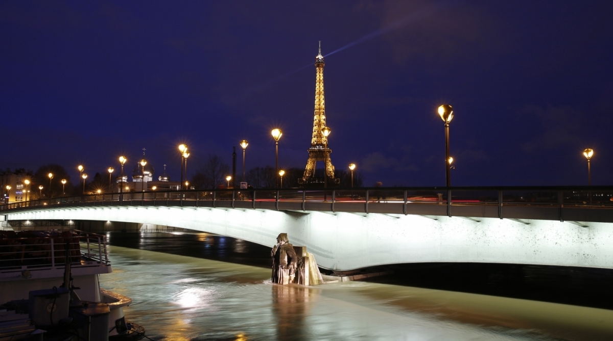 This photo taken on January 25, 2018 in Paris shows an illuminated Eiffel Tower, next to the Seine River, with water levels raised to the height of the Zouave statue of the Pont d'Alma bridge.
The Seine continued to rise on January 25, 2018, flooding streets and putting museums on an emergency footing as record rainfall pushed rivers over their banks across northeastern France. / AFP PHOTO / GEOFFROY VAN DER HASSELT