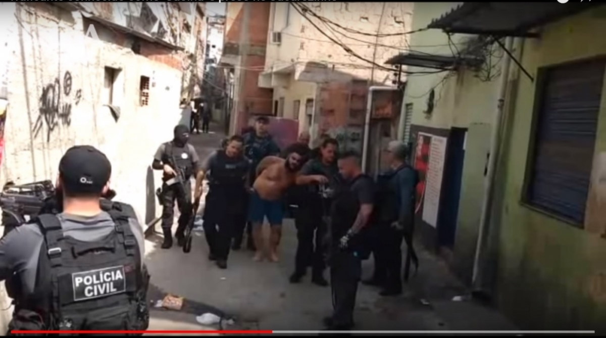 'Caolha', chefe do tráfico local, conduzido por policiais, no Jacarezinho