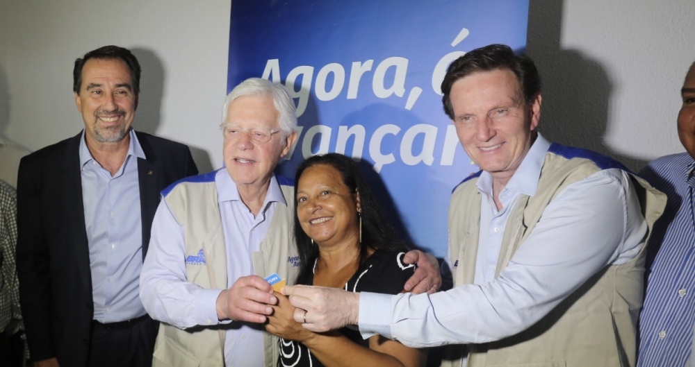 Crivella entrega a chave a uma beneficiada pelo Minha Casa Minha Vida. Ao lado do presidente da Caixa, Gilberto Occhi, e o ministro Moreira Franco