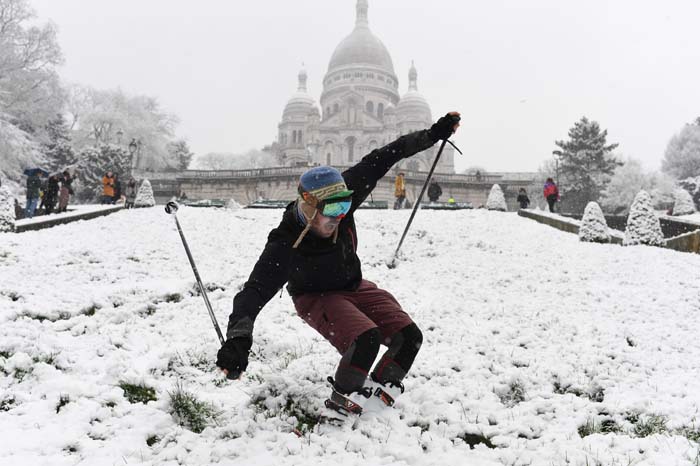 Esquiador se diverte na neve na Basílica do Sagrado Coração, em Paris