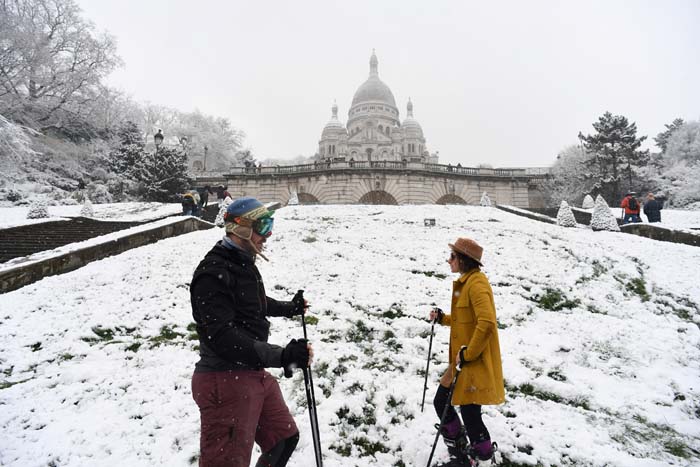 Esquiadores se divertem sobre a neve que cobre a Bas�lia do Sagrado Cora��o, em Montmartre, em Paris