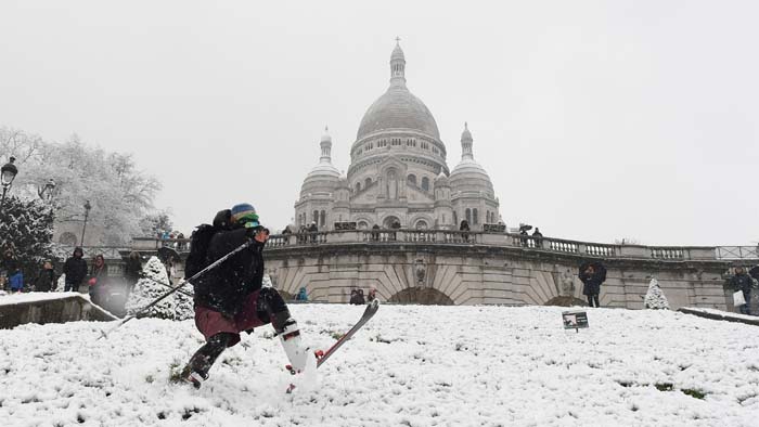 Esquiadores se divertem sobre a neve que cobre a Bas�lia do Sagrado Cora��o, em Montmartre, em Paris