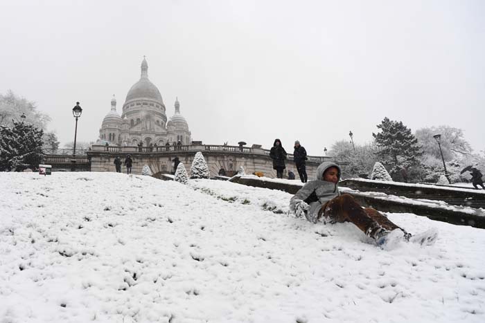 Esquiadores se divertem sobre a neve que cobre a Bas�lia do Sagrado Cora��o, em Montmartre, em Paris