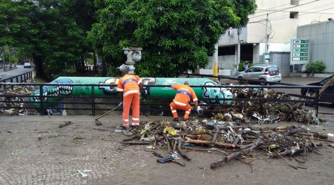 Garis tiram pedaos de galhos no Rio Maracan, que transbordou durante o temporal