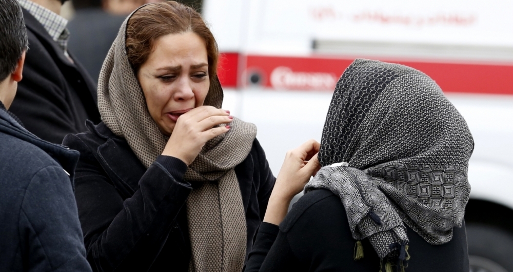 Relatives of Iranian passengers, onboard the Aseman Airlines flight EP3704, react as they gather in front of a mosque near Tehran's Mehrabad airport on February 18, 2018. 
All 66 people on board an Iranian passenger plane were feared dead after it crashed into the country's Zagros mountains, with emergency services struggling to locate the wreckage in blizzard conditions.  / AFP PHOTO / ATTA KENARE
      Caption