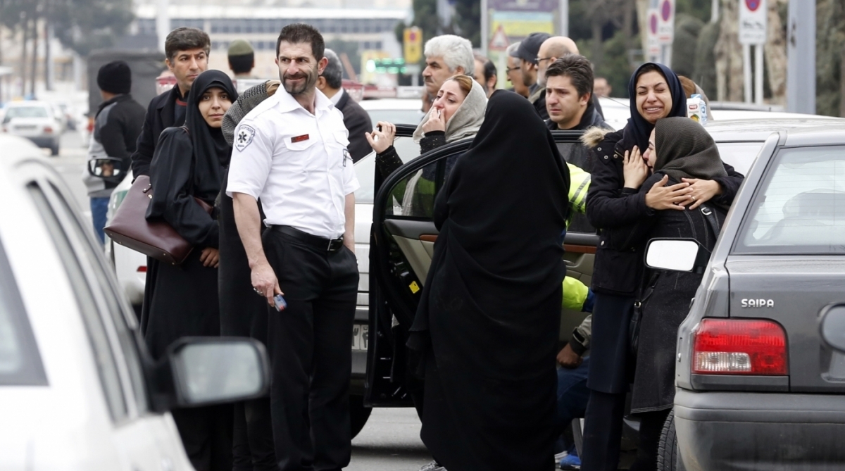 Relatives of Iranian passengers, onboard the Aseman Airlines flight EP3704, react as they gather in front of a mosque near Tehran's Mehrabad airport on February 18, 2018. 
All 66 people on board an Iranian passenger plane were feared dead after it crashed into the country's Zagros mountains, with emergency services struggling to locate the wreckage in blizzard conditions.  / AFP PHOTO / ATTA KENARE
      Caption