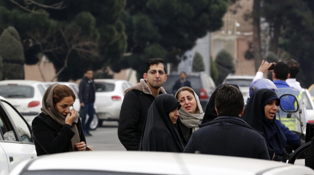Relatives of Iranian passengers, onboard the Aseman Airlines flight EP3704, react as they gather in front of a mosque near Tehran's Mehrabad airport on February 18, 2018. 
All 66 people on board an Iranian passenger plane were feared dead after it crashed into the country's Zagros mountains, with emergency services struggling to locate the wreckage in blizzard conditions.  / AFP PHOTO / ATTA KENARE
      Caption