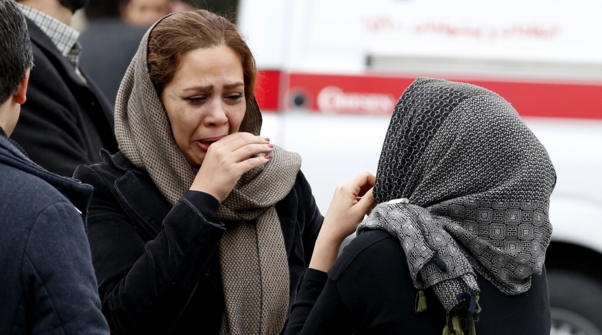 Relatives of Iranian passengers, onboard the Aseman Airlines flight EP3704, react as they gather in front of a mosque near Tehran's Mehrabad airport on February 18, 2018. 
All 66 people on board an Iranian passenger plane were feared dead after it crashed into the country's Zagros mountains, with emergency services struggling to locate the wreckage in blizzard conditions.  / AFP PHOTO / ATTA KENARE
      Caption - AFP