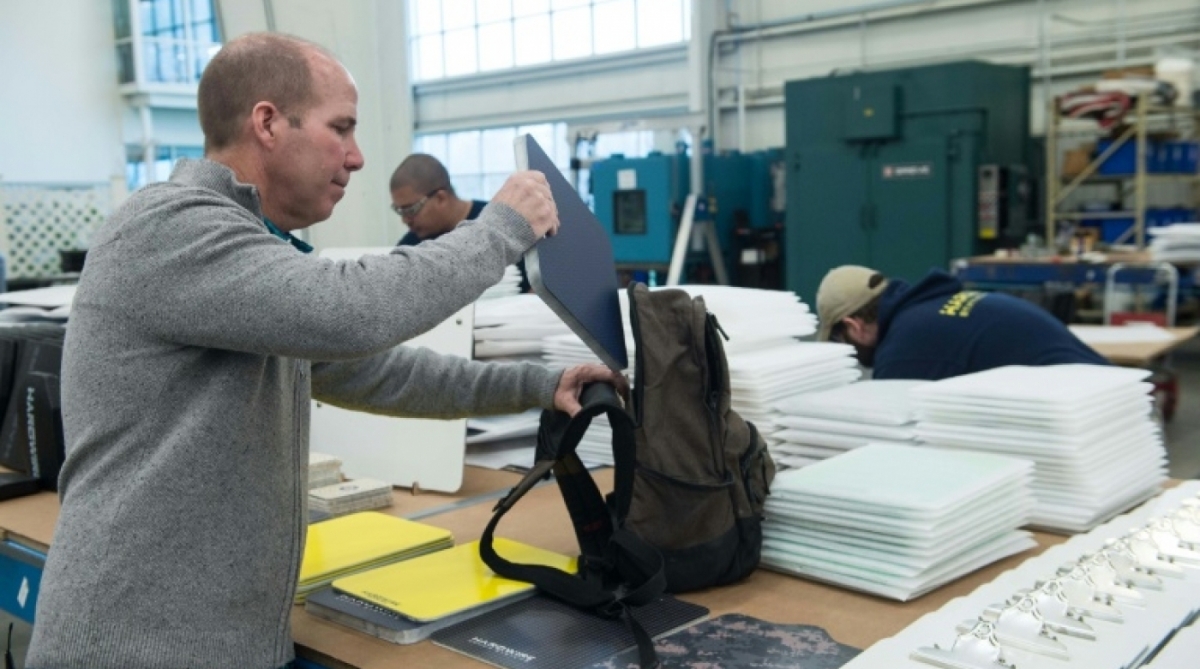 George Tunis, diretor de empresa especializada em proteção à prova de balas, coloca uma placa blindada em uma mochila em sua empresa em Pocomoke City, Maryland.