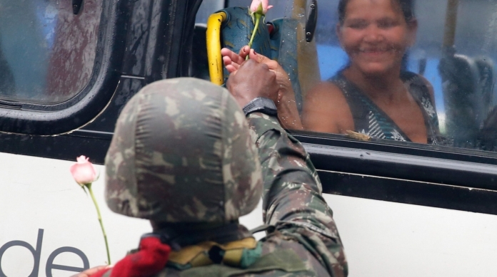 Soldado oferece flor para uma passageira de �nibus: gesto expressa desejo de paz, segundo o Ex�rcito