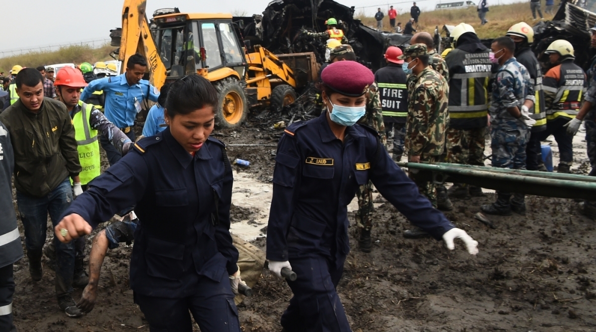 Resgate nepal&ecirc;s remove o corpo de um passageiro dos escombros do avi&atilde;o que caiu perto do aeroporto internacional em Katmandu.