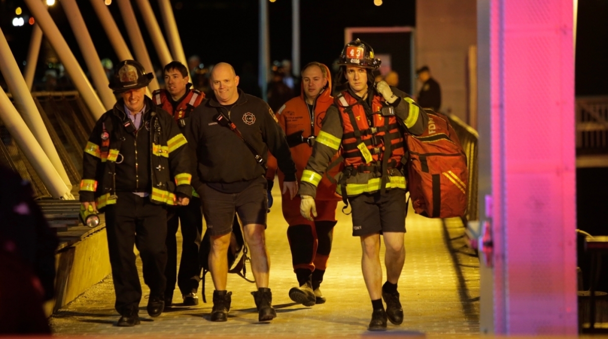 Primeiros socorros atendem a chamado depois de um helicóptero cair no East River, em Nova Iorque.