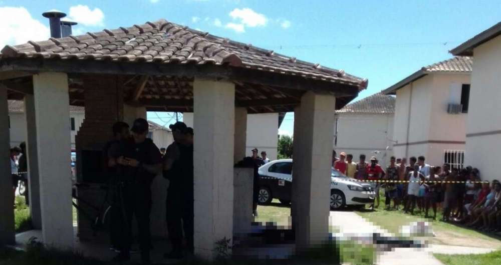 Moradores observam os corpos e policiais fazem a per�cia no local 