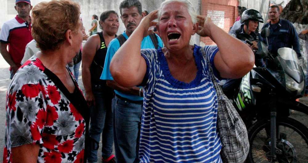 Parente de prisioneiro chora em frente a uma delegacia em Valencia, na Venezuela.