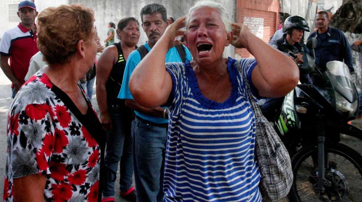 Parente de prisioneiro chora em frente a uma delegacia em Valencia, na Venezuela. - AFP