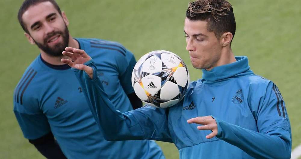 Observado por Carvajal, Cristiano Ronaldo brinca com a bola durante o treino do Real Madrid em Turim