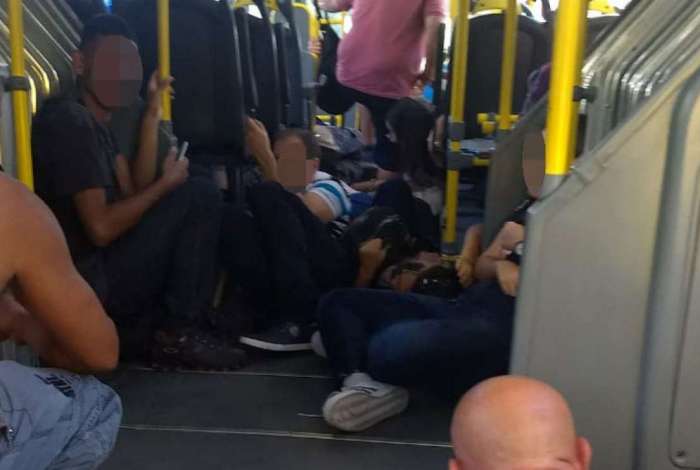 Passageiros de BRT se agacham para se protegerem dos tiros de confronto no Bateau Mouche, na Pra�a Seca