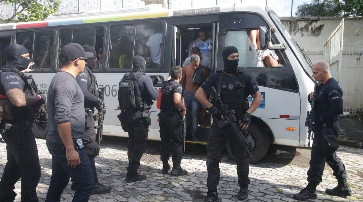 Cerca de 80 detidos em Santa Cruz na rua Fernanda foram levados para Cidade da Pol&iacute;cia na manh&atilde; deste s&aacute;bado. Eles chegaram em dois &ocirc;nibus acompanhados de policiais do Core. Segundo conversa de policiais civis dos 3 um quebrou o p&eacute; e ser&atilde;o presos por tentativa de homic&iacute;dio, pois entraram em confronto com os policiais. Foto: Daniel Castelo Branco / Ag&ecirc;ncia O Dia