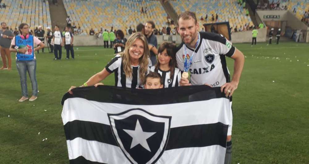 Joel Carli posa com a bandeira do Fog�o, ao lado dos filhos e da esposa: volta por cima e volta ol�mpica