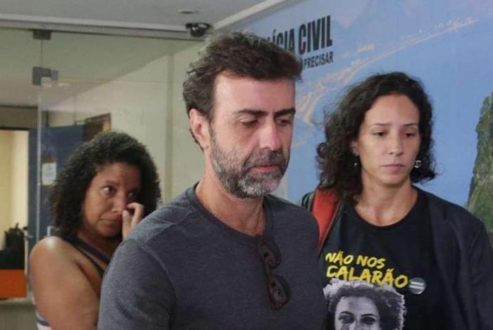 A arquiteta Mônica Benício, viúva de Marielle Franco, é acompanhada pelo deputado estadual Marcelo Freixo no prédio da Chefia da Polícia Civil em encontro sobre investigação do assassinato da vereadora.