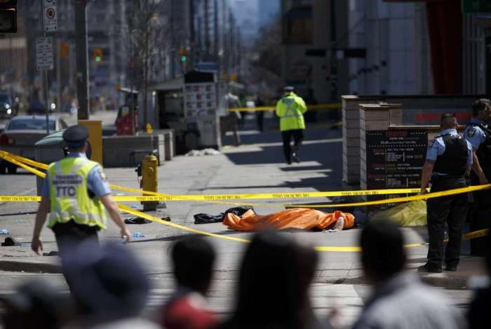 Uma lona cobre um corpo na rua Young, na transversal com a avenida Finch, depois que uma van atropelou pedestres em Toronto, Canadá.