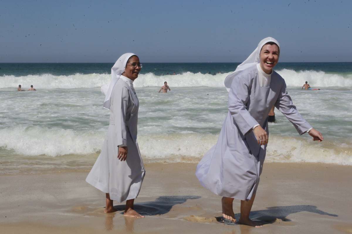 Freiras se divertem no Recreio, no Dia do Trabalhador. Elas participaram de missa em homenagem a Guido Shäffer, surfista que pode virar santo