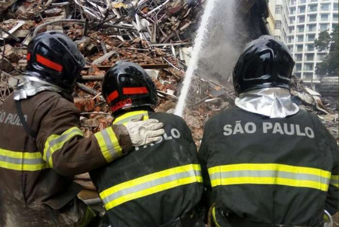 Bombeiros trabalham no resfriamento dos escombros