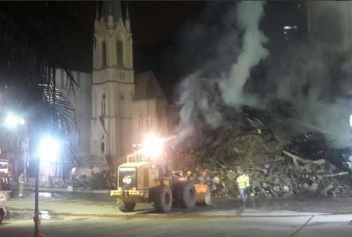 No in�cio da manh�, bombeiros usam maquin�rio pesado para retirada de escombros, no largo h� 20 viaturas com 62 homens empenhados na miss�o