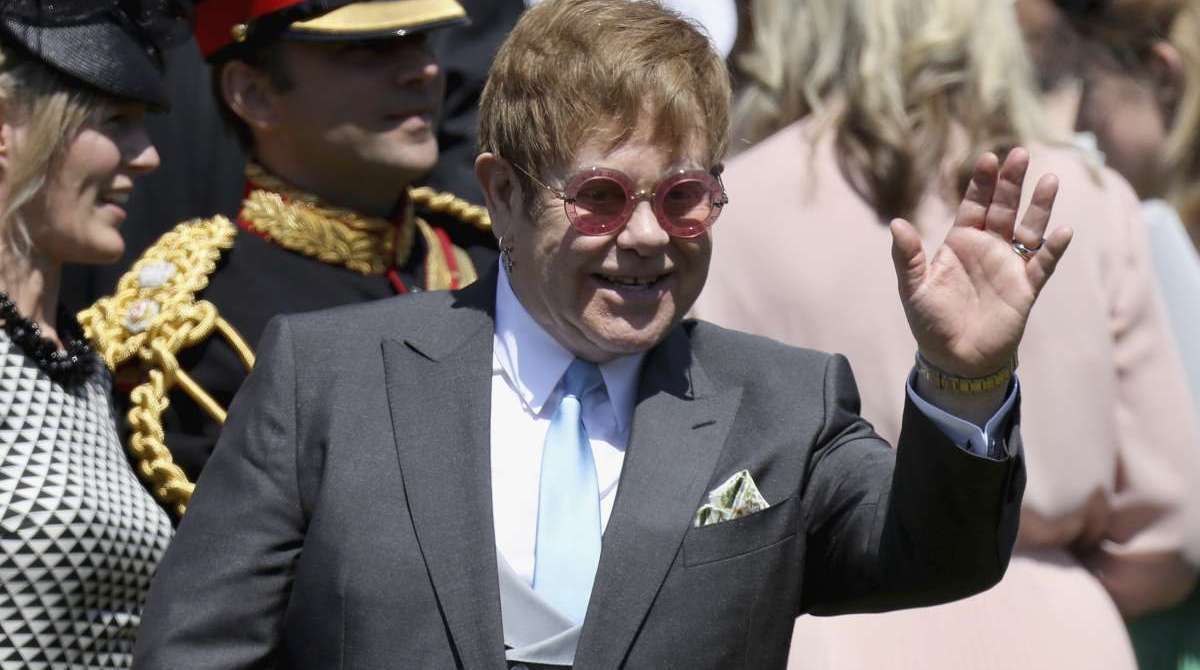O cantor e compositor britânico Elton John acena ao sair depois de participar da cerimônia de casamento do príncipe Harry, duque de Sussex e da atriz norte-americana Meghan Markle