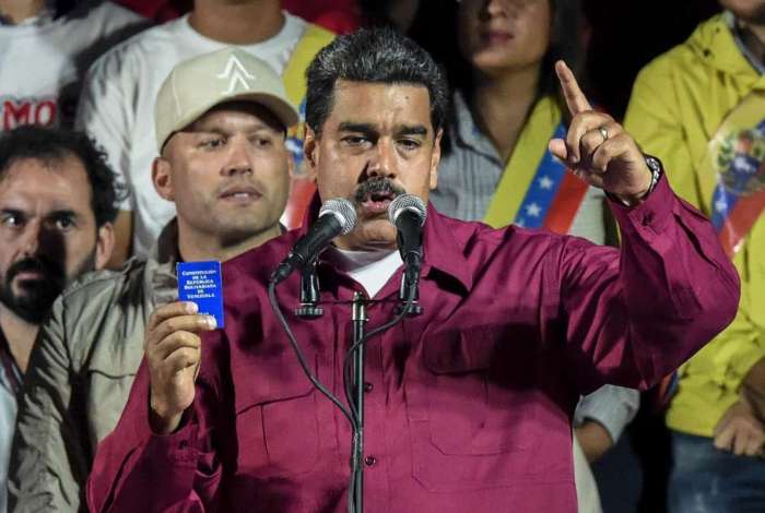 O presidente venezuelano Nicolas Maduro segura a Constituio durante discurso aps o Conselho Nacional Eleitoral anunciar os resultados das eleies presidenciais