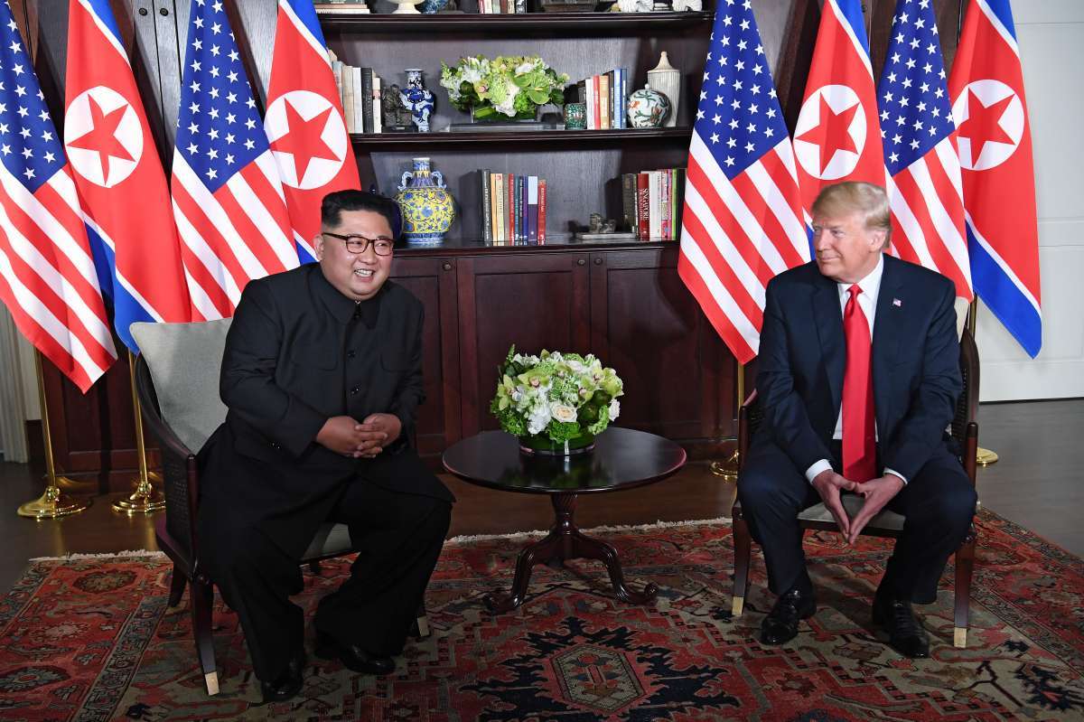 US President Donald Trump (R) poses with North Korea's leader Kim Jong Un (L) at the start of their historic US-North Korea summit, at the Capella Hotel on Sentosa island in Singapore on June 12, 2018. Donald Trump and Kim Jong Un have become on June 12 the first sitting US and North Korean leaders to meet, shake hands and negotiate to end a decades-old nuclear stand-off. / AFP PHOTO / SAUL LOEB