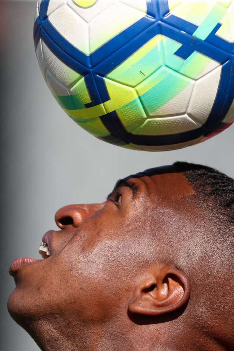 Vinicius Júnior, atacante do Flamengo, controla a bola com a cabeça, em treino no Ninho do Urubu