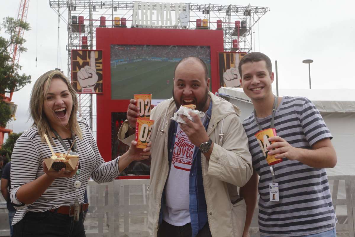 14/06/2018 - Pessoas assistem a abertura da Copa do Mundo Copa na Praça Mauá. Jogo Russia x Arábia Saudita. NA FOTO: E/D Alessandra Duncan, Carlos Eduardo e Bernardino siqueira. Foto de Maíra Coelho / Agência O Dia. Cidade, Futebol, Hora, Almoço, Jogo, Russia,Chuva, Brasil