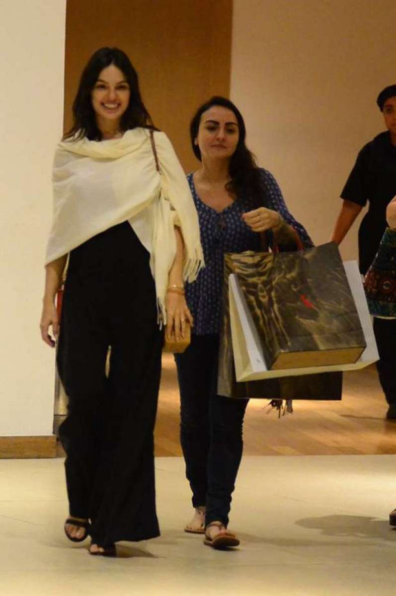 Grávida, Isis Valverde conta com ajuda para carregar suas compras. Atriz espalhou simpatia em shopping no Rio