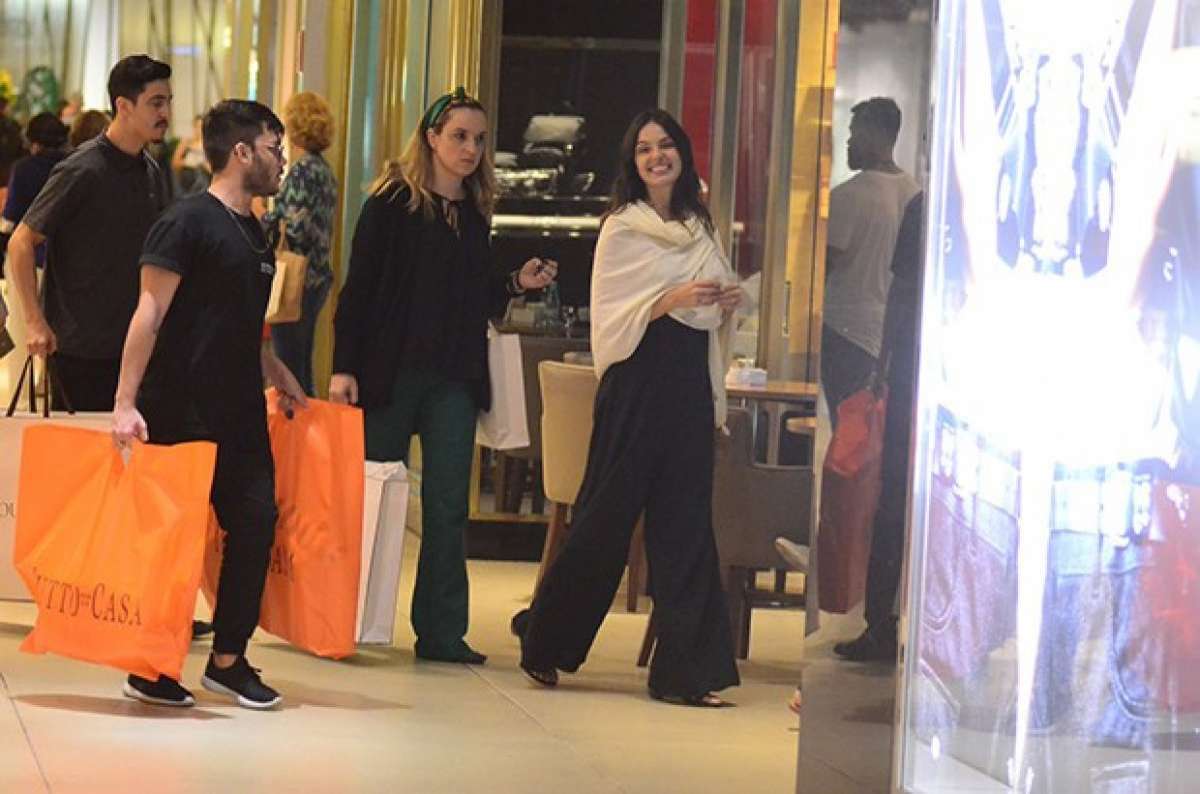 Grávida, Isis Valverde conta com ajuda para carregar suas compras. Atriz espalhou simpatia em shopping no Rio