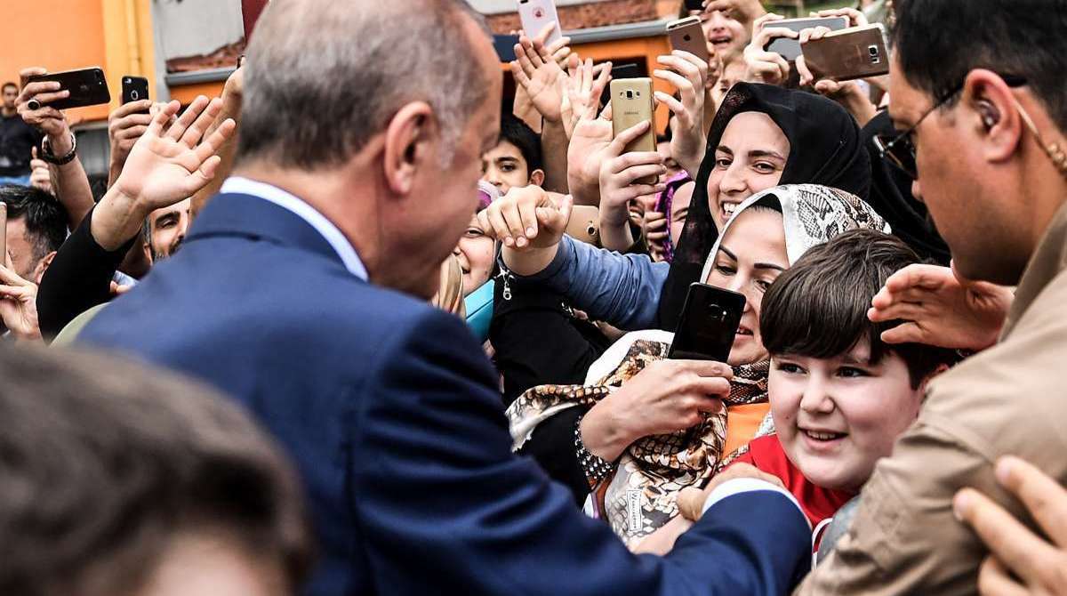 O presidente da Turquia, Recep Tayyip Erdogan, é saudado depois de votar durante as eleições presidenciais e parlamentares turcas em Istambul. - AFP photo/ Bulent Kilic