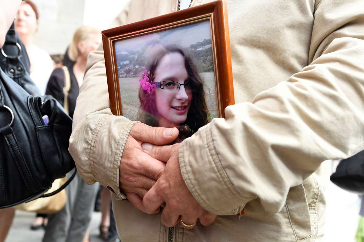 Homem segura retrato da jovem francesa Sophie Lionnet após seu funeral em Sens. (AFP PHOTO / Bertrand Guay)