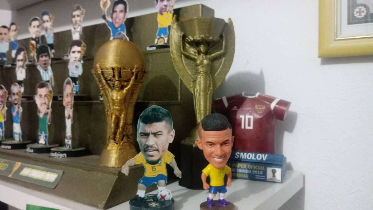 Artesão produz mini craques e até uma reprodução da taça da Copa do Mundo. Produtos são vendidos pela internet