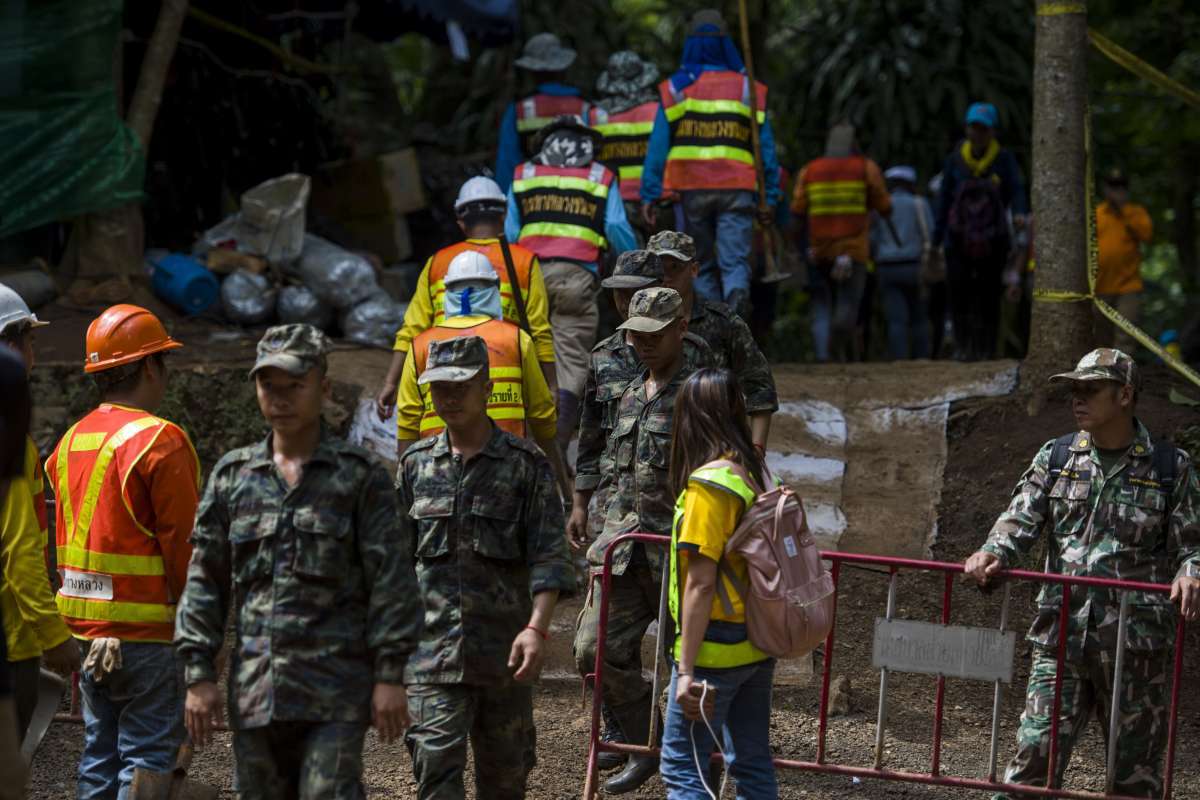 Thai soldiers and volunteers are seen at the entrance of Tham Luang cave at the Khun Nam Nang Non Forest Park in Mae Sai district of Chiang Rai province on July 5, 2018.
Thai rescuers vowed to take a "no risk" approach to freeing 12 boys and their football coach from a flooded cave, as fresh video emerged on July 4 showing the team in good spirits following their astonishing discovery nine days after going missing. / AFP PHOTO / YE AUNG THU
      Caption