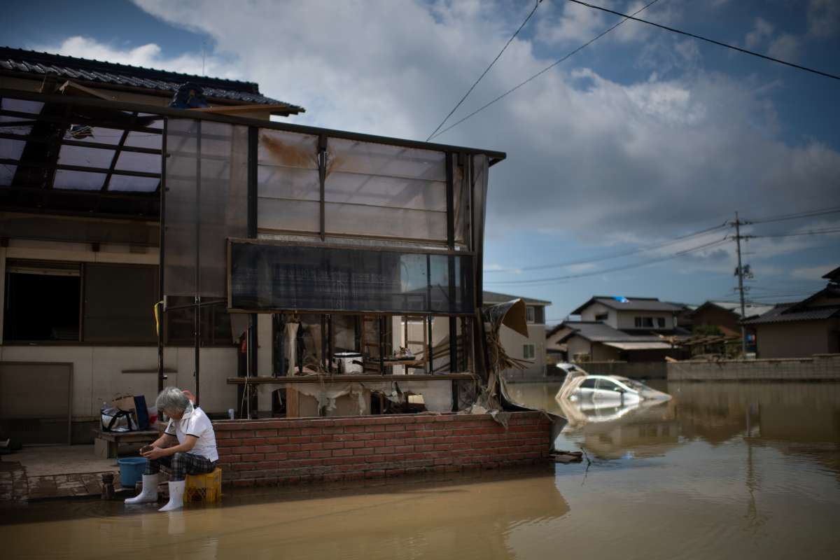 As pessoas inspecionam suas casas danificadas em uma área atingida pela enchente em Mabi