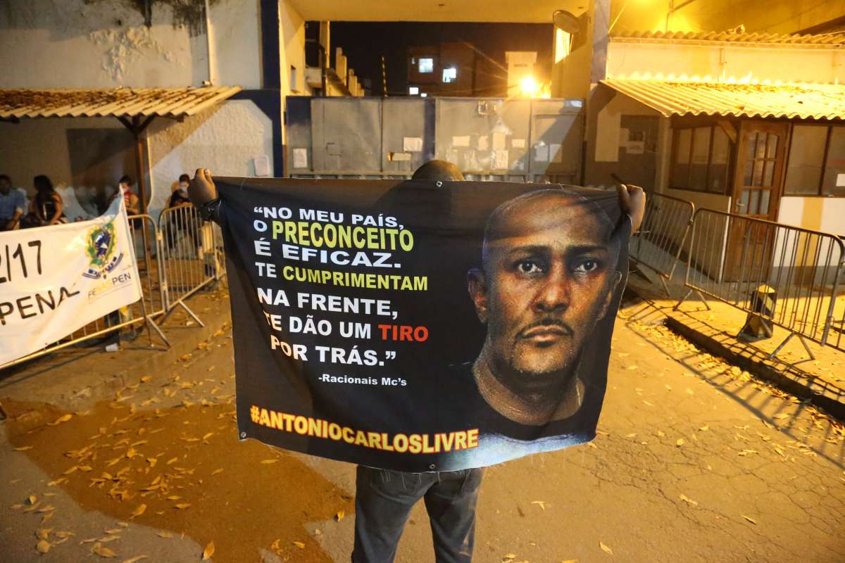 Antonio Carlos Rodrigues Junior, preso no lugar de um criminoso que roubou a cônsul-geral adjunta da Venezuela no Rio, aguarda a soltura do motorista que ficou sete dias detido na Cadeia de Benfica, na Zona Norte do Rio. O ofício confirmando a soltura foi entregue somente na noite desta sexta-feira depois de dias de angústia para a família de Prw, como o homem é conhecido entre os amigos. Na foto Leonardo Ribeiro( irmao do preso) com uma bandeira com a foto do irmao e a esposa de preto e cabelo logo, Inggred Luna. Foto: Daniel Castelo Branco / Agencia O Dia