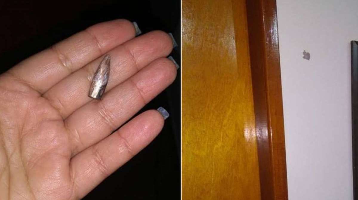 A moradora mostra a bala que atingiu sua casa